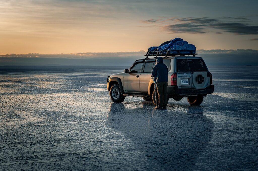 couple standing by a jeep in wet flat landscape