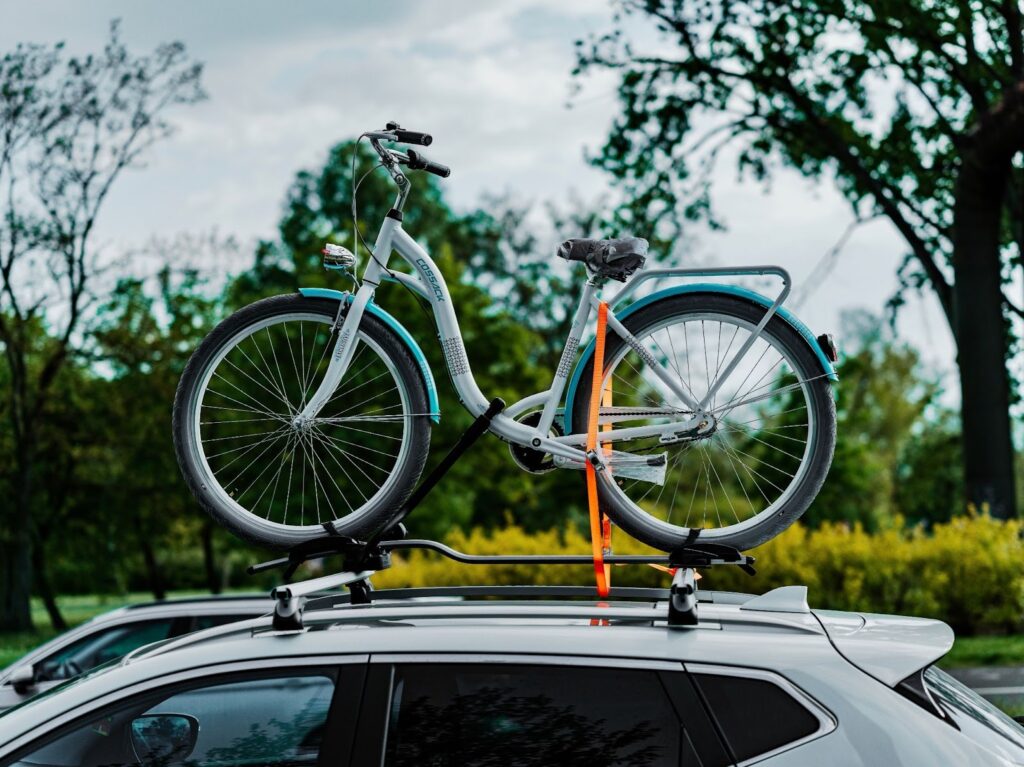 a bicycle on top of a car in a parking lot
