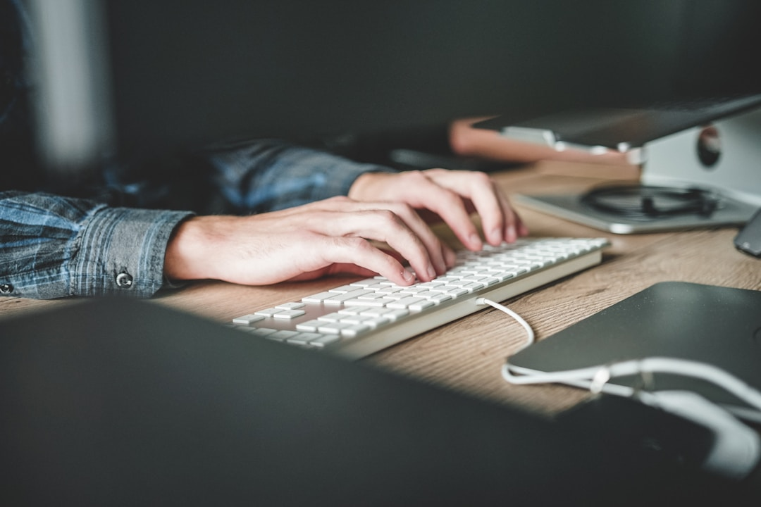 A person typing on a keyboard at a desk, using top proposal software to create a document.
